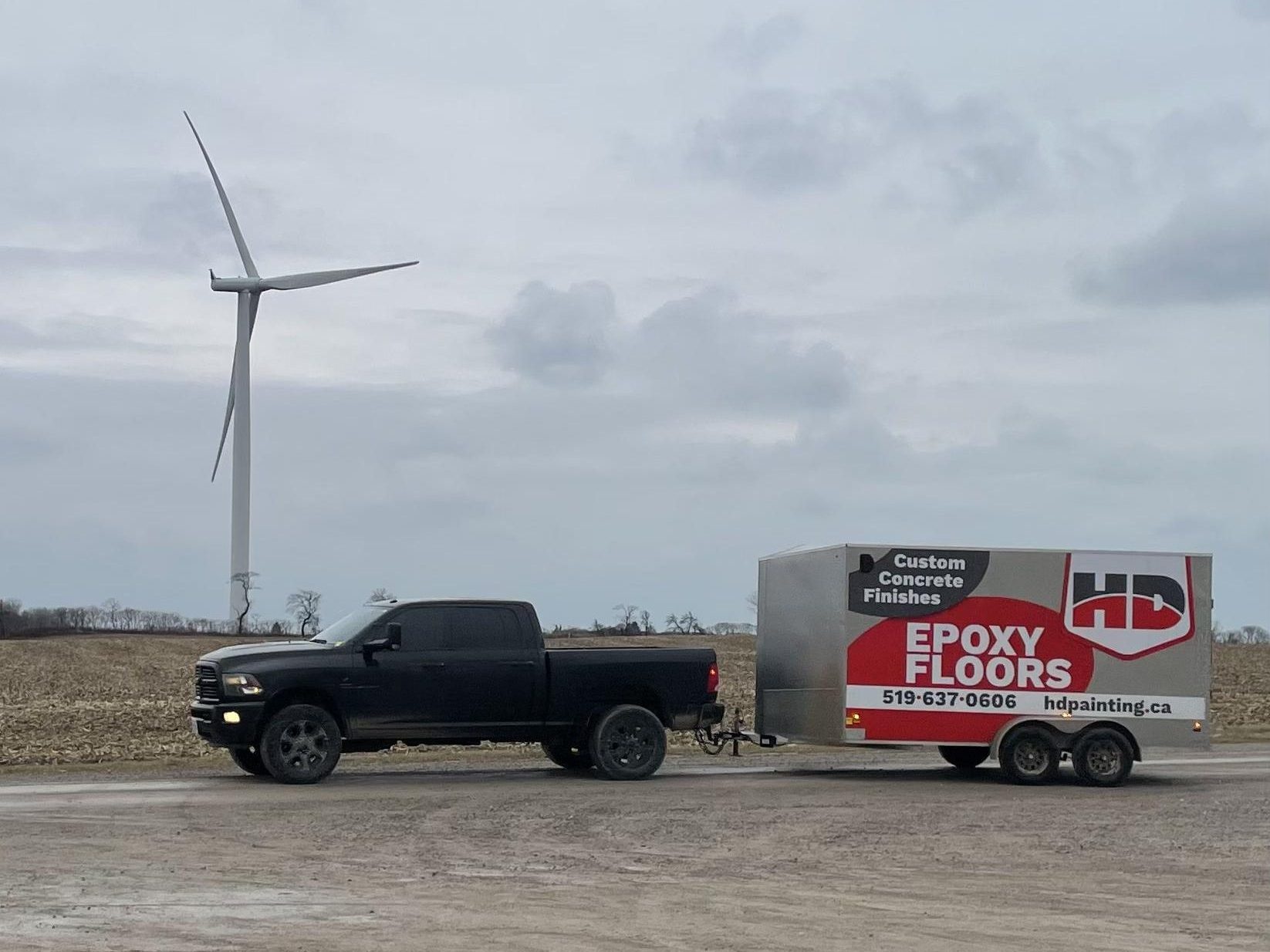 Truck pulling a cargo trailer with the HD Painting logo on it.